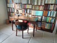 bureau Louis Phillipe noyer et son mur de livres derri&egrave;re.